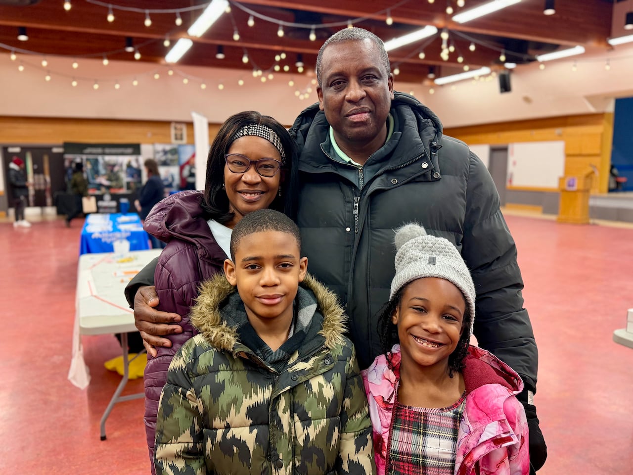 A man and a woman posing for a picture with two children (a boy and a girl).