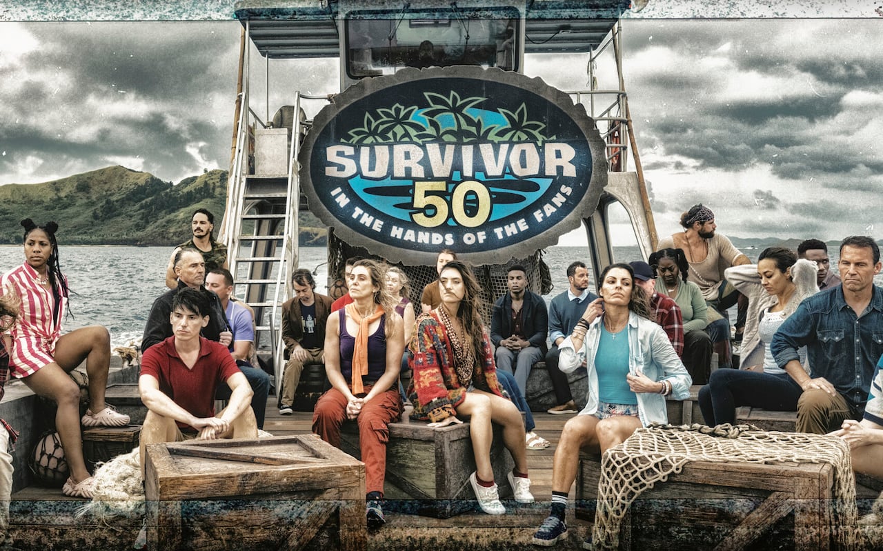 People sit on a boat with a big logo that says Survivor.