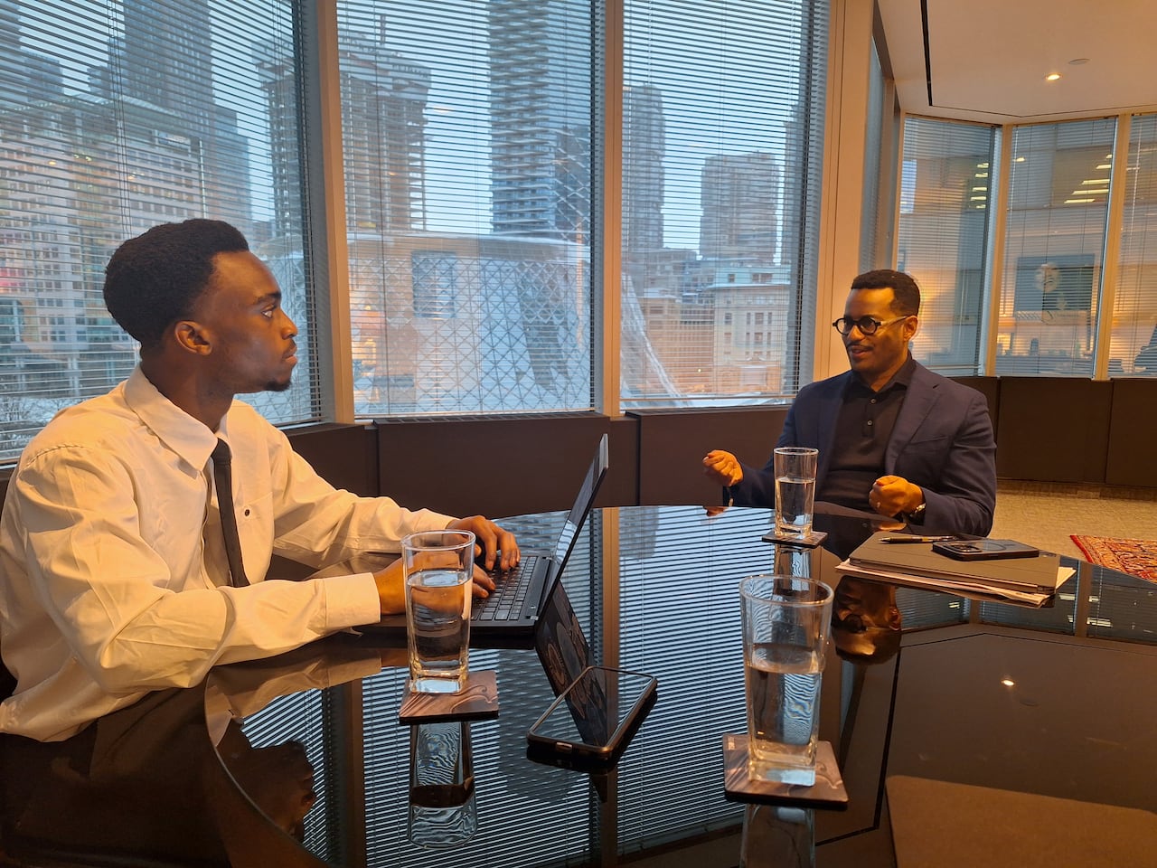 Student and man speak at a table.