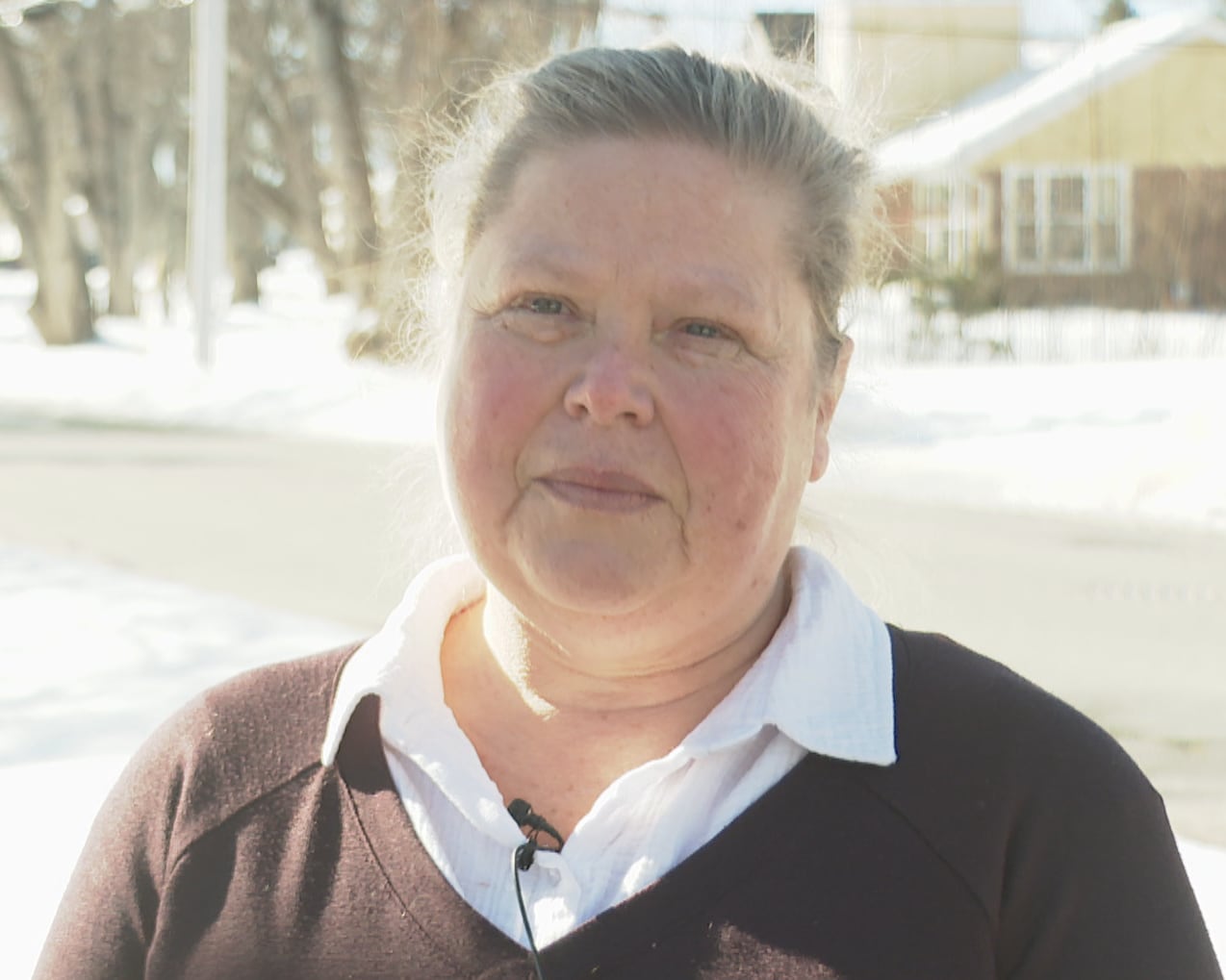 A woman with a neutral expression who has white hair.