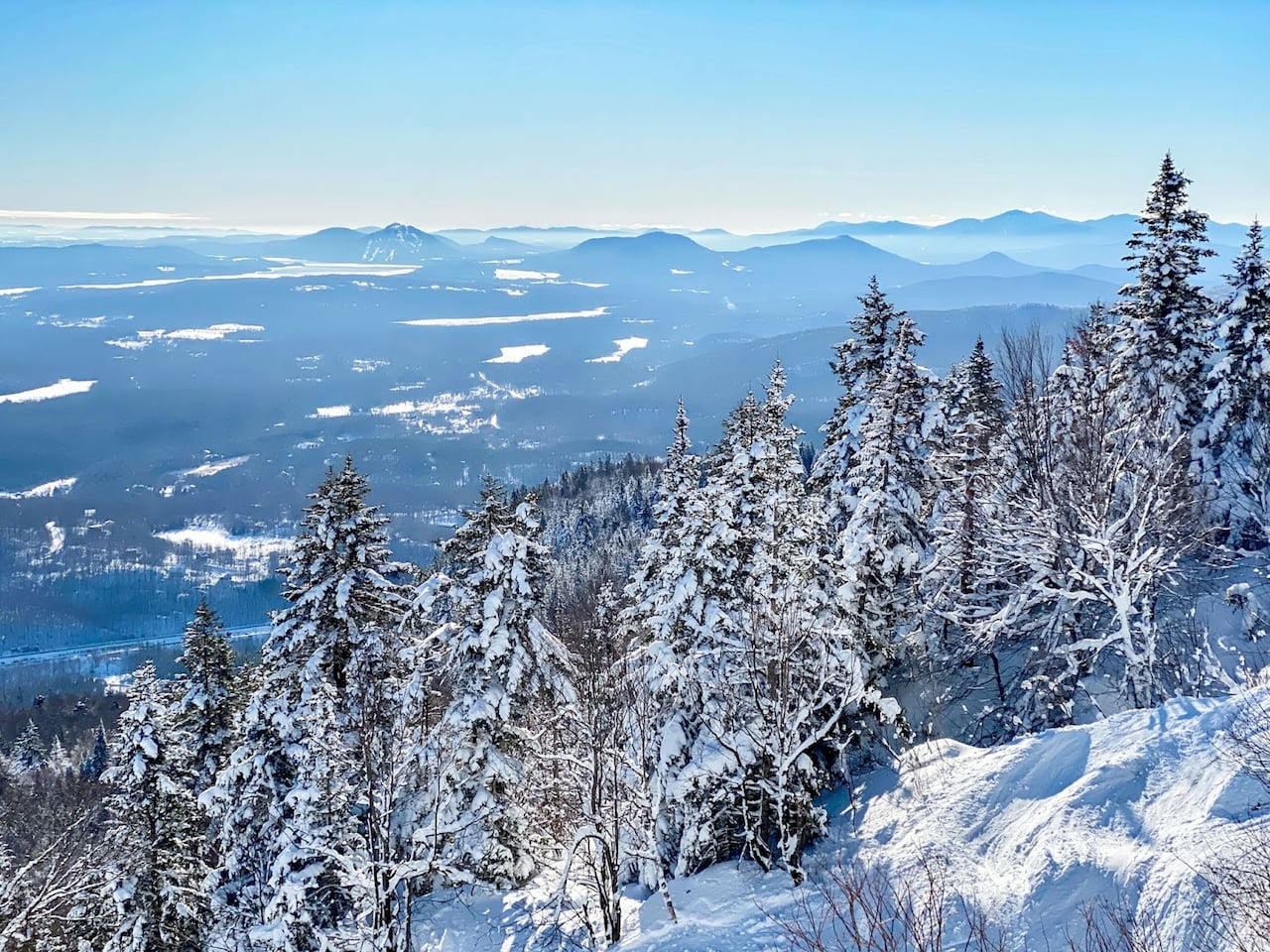 The view from a summit of a snowy mountain.