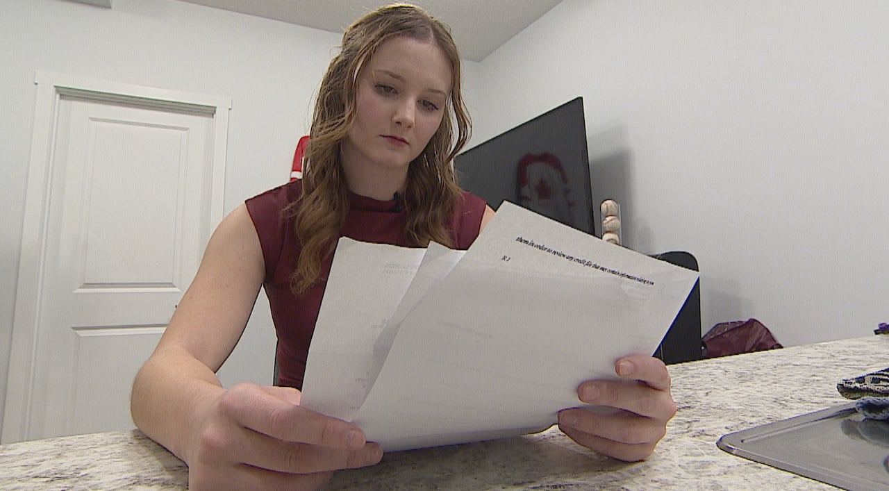 Woman seated at counter top, looking over papers