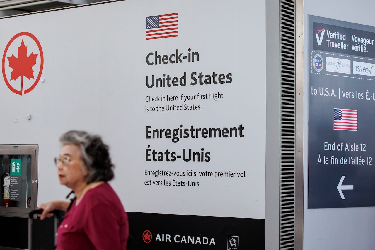 A senior aged woman in red shirt passes by US customs at Pearson airport