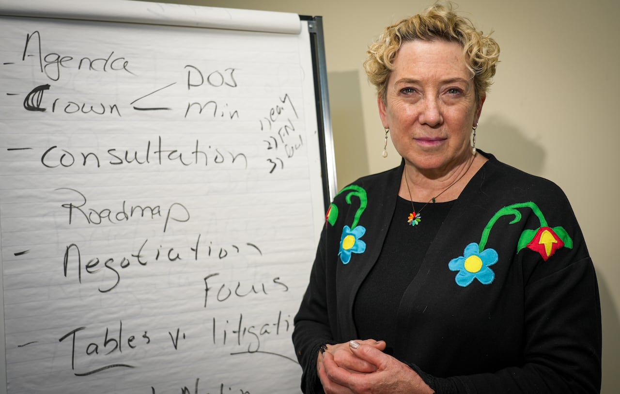 A professor stands in front of a chart board that has words written on it like "DOJ" and "negotiations."
