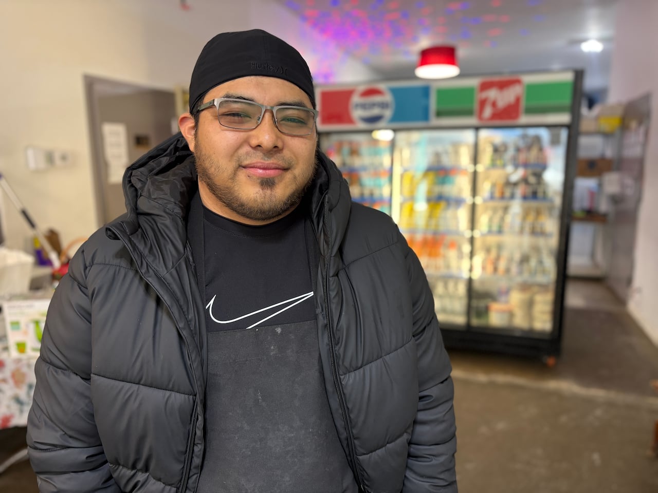 A man dressed in black is standing in a café