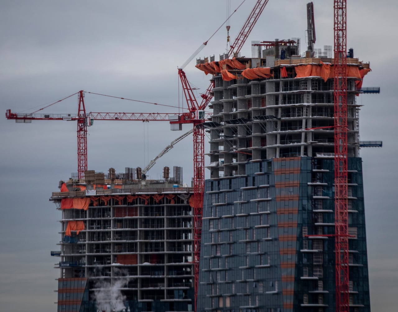 Cranes work on two large skyscrapers.