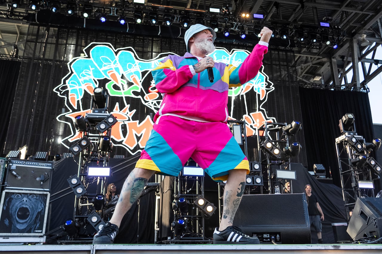 A musician in bright clothes performs at a stadium.