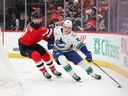Winger Liam Ohgren of the Vancouver Canucks makes a power move to fend off defenceman Dougie Hamilton of the New Jersey Devils on Dec. 14.