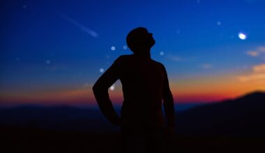 Person looking up at stars and planets in the night sky, stargazing. Credit: M-Gucci / Getty Images