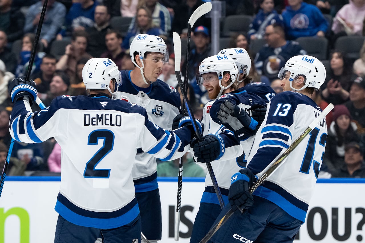 Five Winnipeg Jets teammates celebrate.