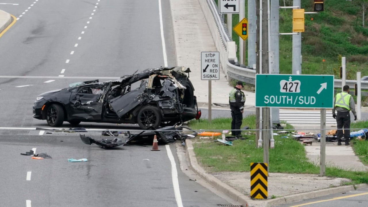 Photo of a black car wreck in daylight