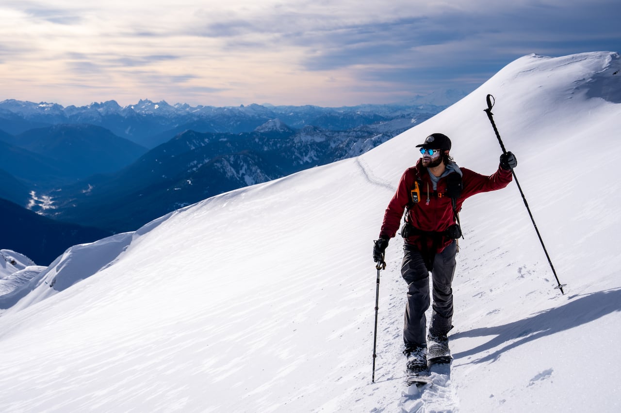 A man stops on the side of a mountain. 