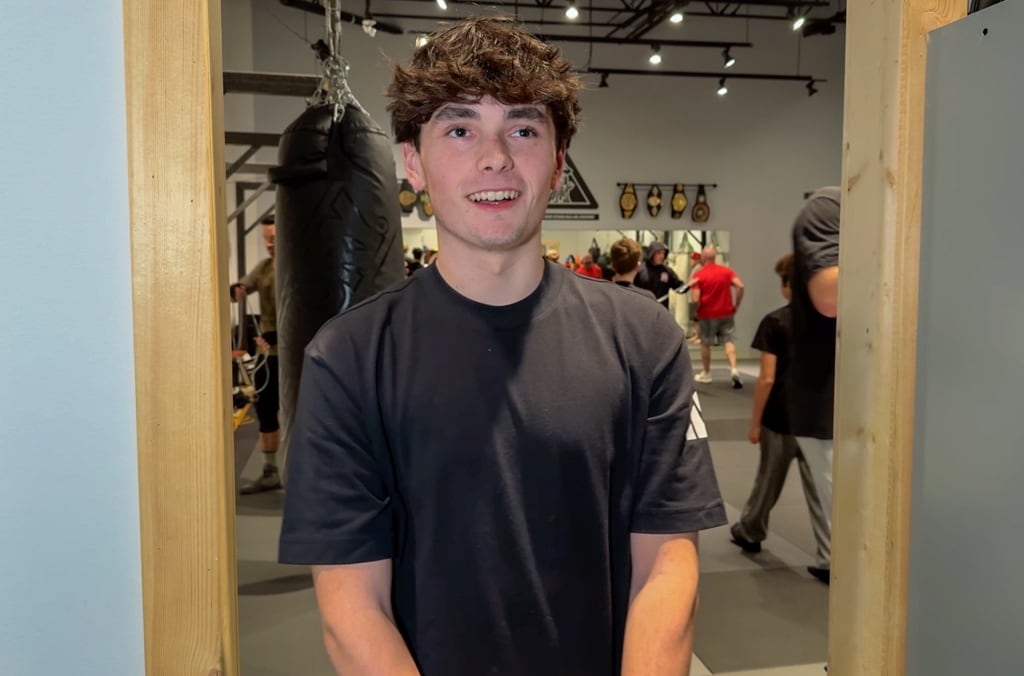 A boy wearing a black shirt smiles