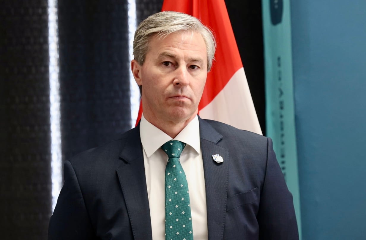 A man in a suit with a stern face.