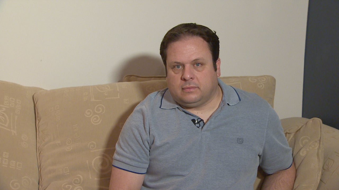 A man sits on a couch. 