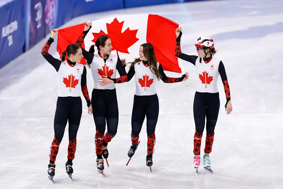 MILAN, ITALY - FEBRUARY 18: Courtney Sarault of Canada, Danae Blais of Canada, Kim Boutin of Canada, Florence Brunelle of Canada celebrating with flag after competing in the Women's 3000m Relay during Day 12 of Short Track Speed Skating - Milano Cortina 2026 Winter Olympics at Milano Ice Skating Arena on February 18, 2026 in Milan, Italy. (Photo by Joris Verwijst/BSR Agency/Getty Images)