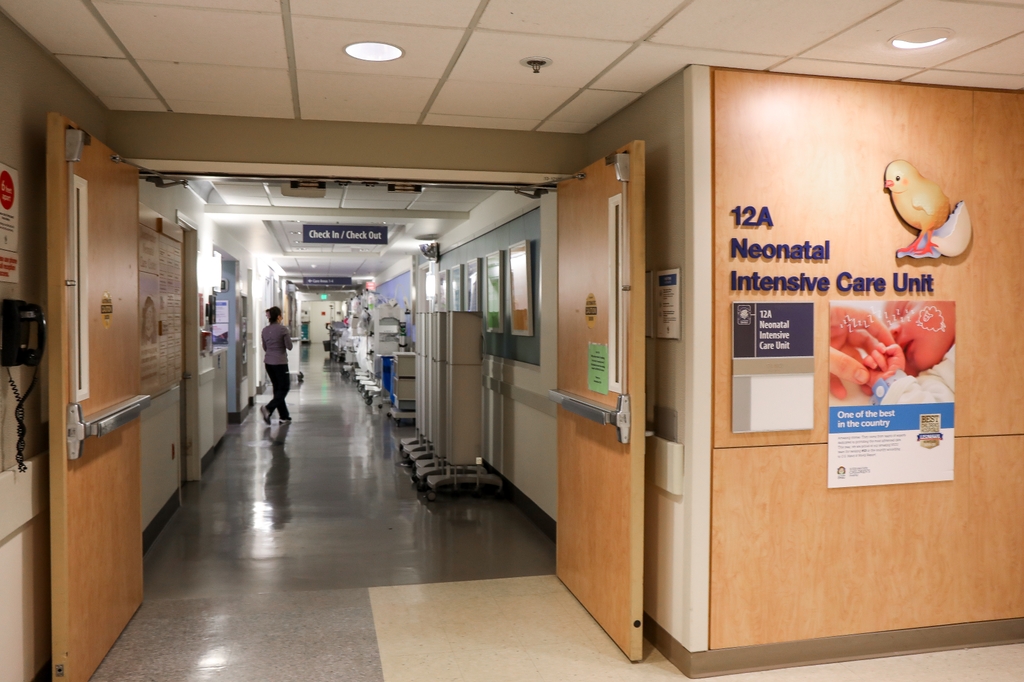 OHSU NICU sign and doors open with a nurse walking by.