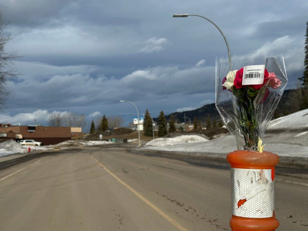 A bouquet of flowers sticks out of a road barricade in Tumbler Ridge