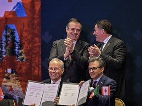 Internal Trade Minister Dominic LeBlanc and Mexico's Secretary of Economy Marcelo Ebrard applaud during the signing of an MOU.