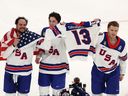 Auston Matthews, Zach Werenski and Matthew Tkachuk of Team United States celebrate winning the gold medal with the sweater of the late Johnny Gaudreau after the team's 2-1 overtime victory in men's hockey between Canada and the United States on Day 16 of the Milan- Cortina 2026 Winter Olympic Games at Milano Santagiulia Ice Hockey Arena on Sunday, Feb. 22, 2026, in Milan, Italy.