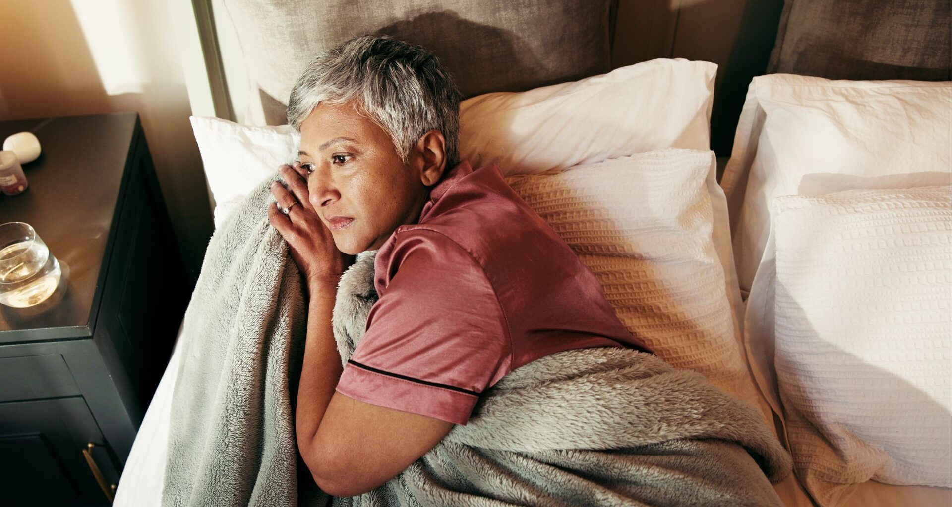 woman lays awake on bed unable to sleep