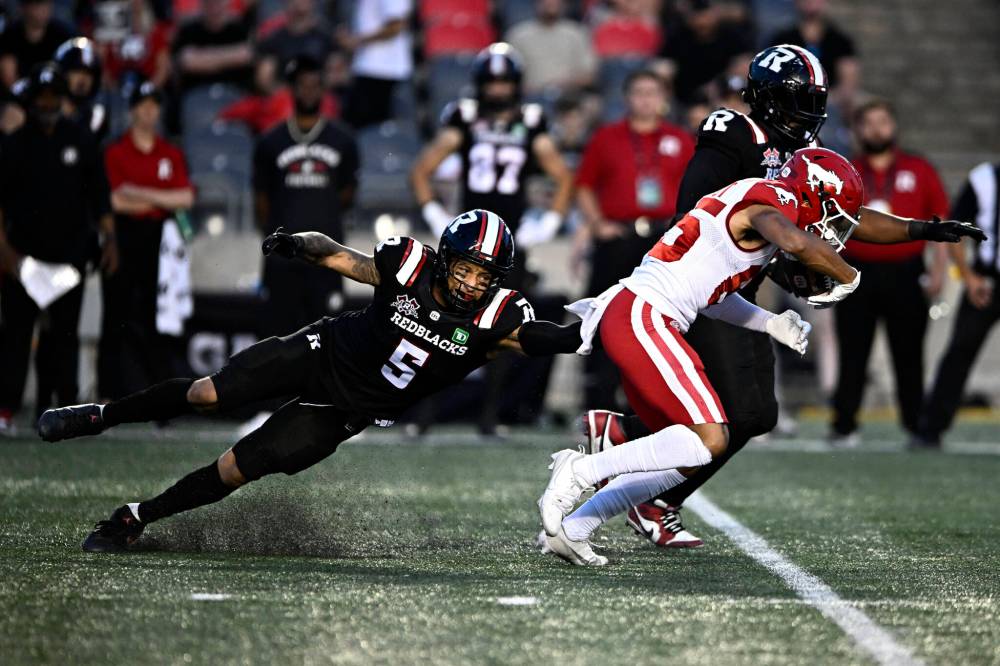 JUSTIN TANG / THE CANADIAN PRESS FILES
Linebacker Jovan Santos-Knox (left) goes to tackle Calgary Stampeders’ Jalen Philpot last season. Santos-Knox signed a one-year deal with his former team, the Winnipeg Blue Bombers, on Tuesday.