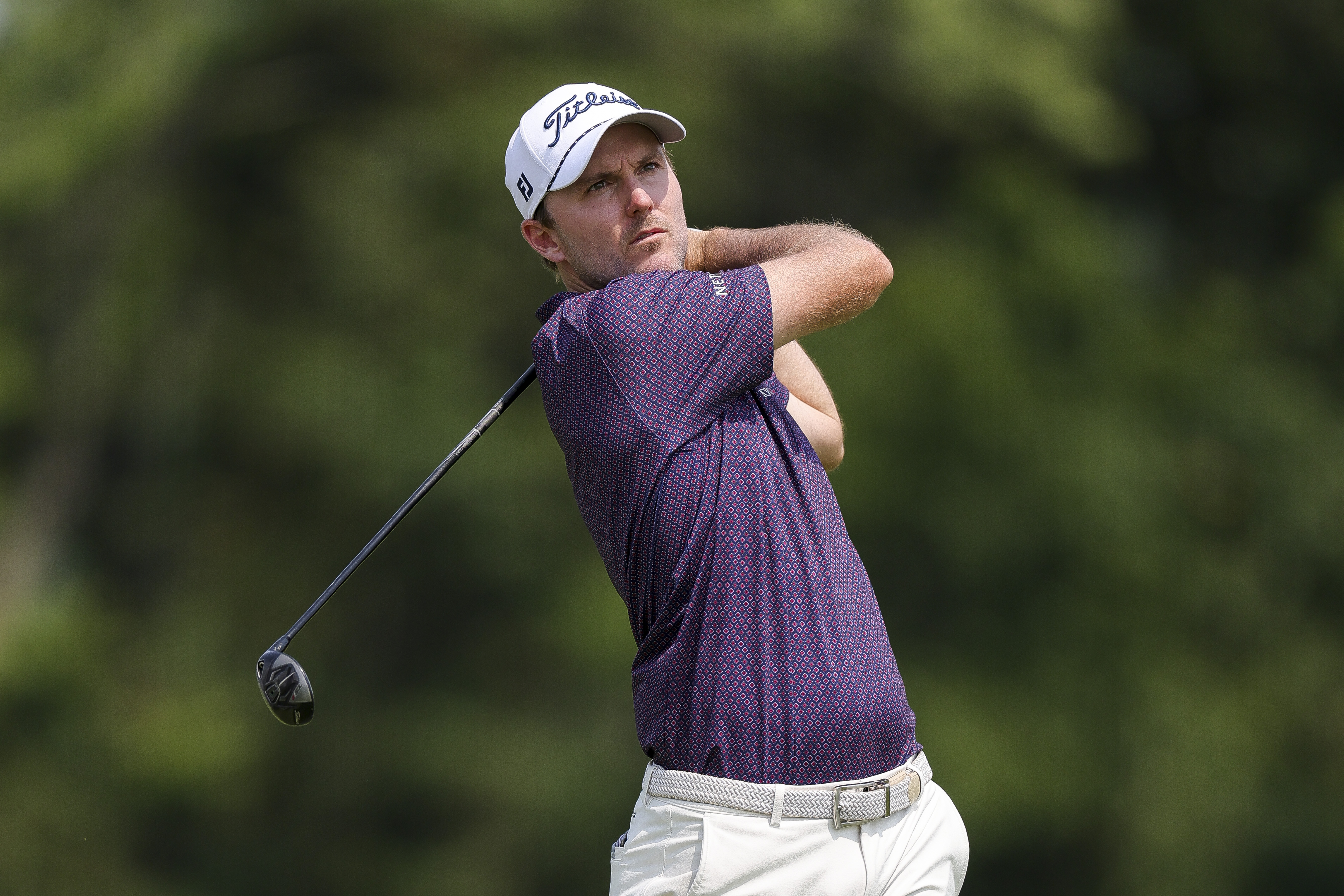 Russell Henley hits a hybrid from the fairway