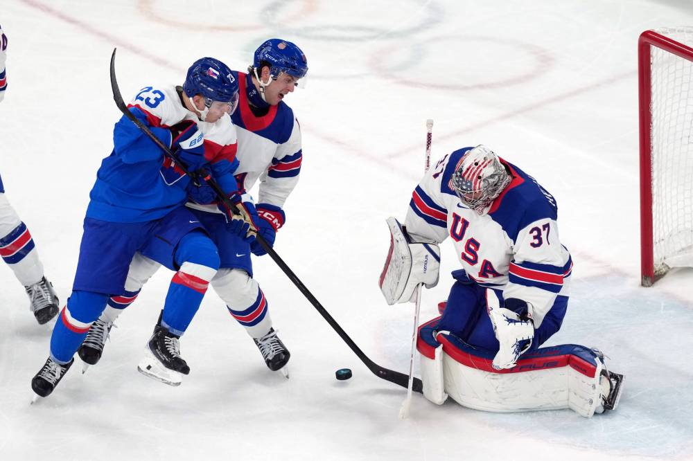 CAROLYN KASTER / THE ASSOCIATED PRESS
Slovakia’s Adam Liska (23) battles with United States’ Brock Faber (centre) for the puck in front of U.S. goalie Connor Hellebuyck (37) during the third-period of the semifinal game at the 2026 Winter Olympics in Milan, Italy.