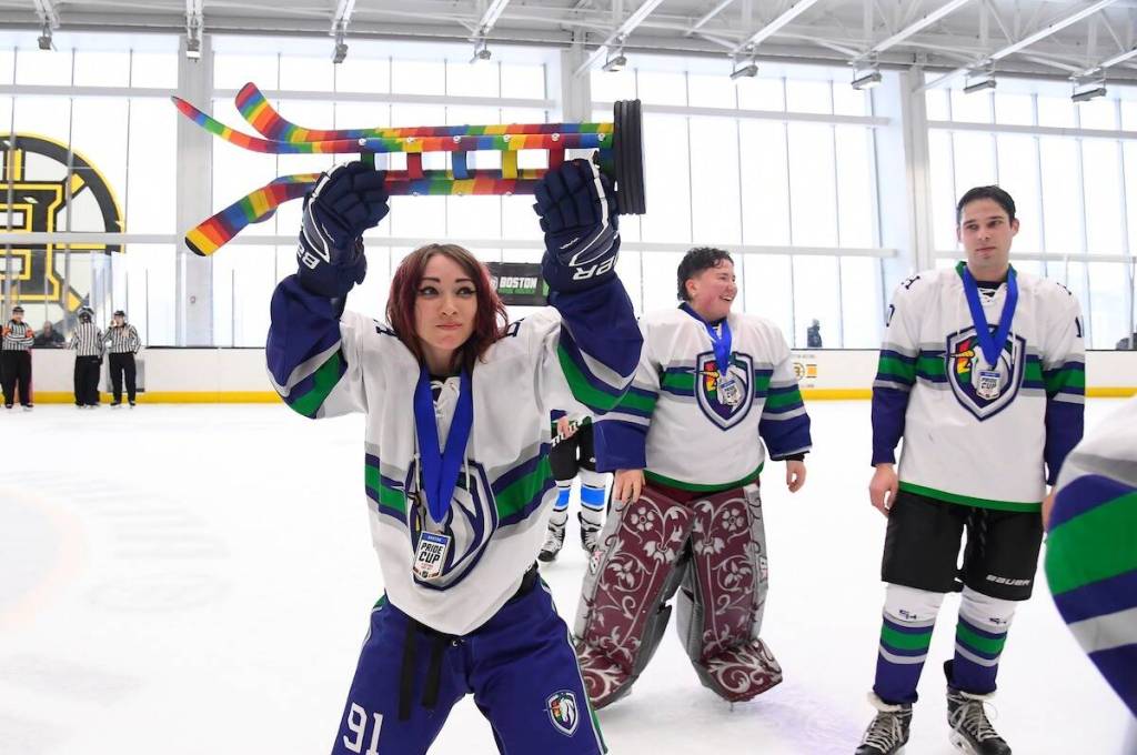 NHL Pride Cup trophy lifted by a hockey player at a rink in Boston, MA, in February 2025. (Photo: Brian Babineau via facebook.com/NHLUnites)