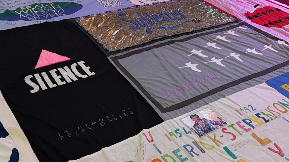 A close up view of a panel of the quilt with various tributes and names - including Sylvester, Peter Davis and Andrew