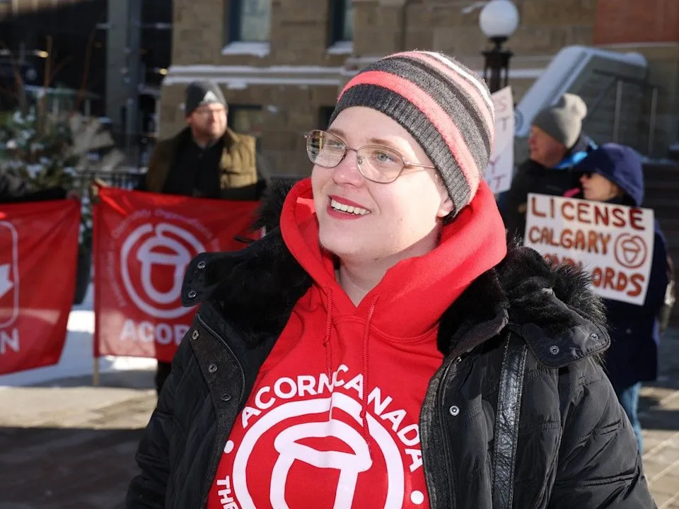  Abi Martin with ACORN Calgary speaks with media during a rally outside Calgary City Hall on Friday, February 20, 2026.
