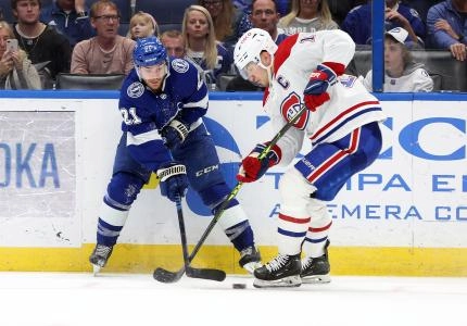 Dec 28, 2022; Tampa, Florida, USA; Tampa Bay Lightning center Brayden Point (21) and Montreal Canadiens center Nick Suzuki (14) fight to control the puck during the third period at Amalie Arena. Mandatory Credit: Kim Klement-Imagn Images