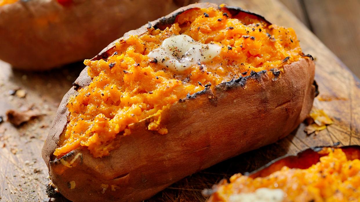 Twice Baked, Stuffed Sweet Potatoes with Melting Butter and Cracked Pepper on cutting board.