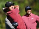 FILE- Charlie Woods tees off on the fifth hole as his father Tiger Woods watches during the final round of the PNC Championship golf tournament, Sunday, Dec. 22, 2024, in Orlando, Fla.