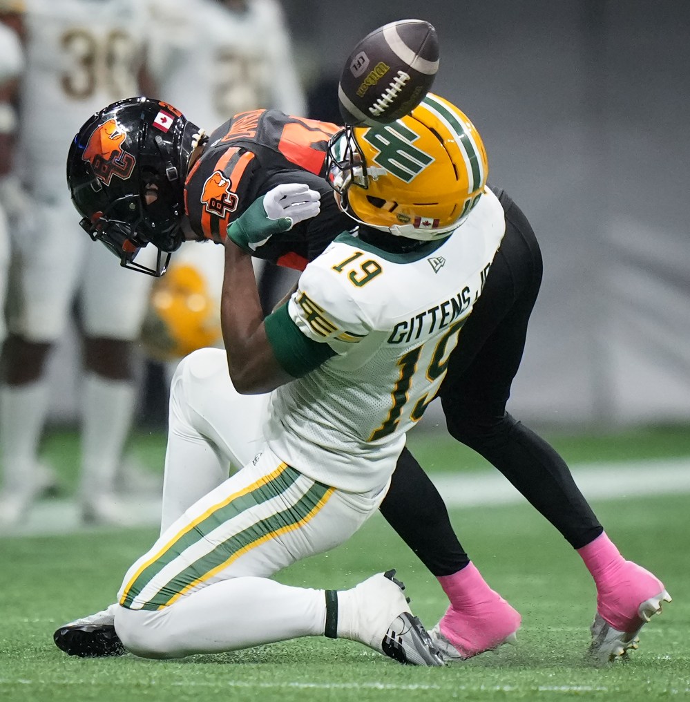 Edmonton Elks' Kurleigh Gittens Jr., front is unable to hold onto the ball on a reception as he's hit by B.C. Lions' Robert Carter Jr. during the second half of a CFL football game, in Vancouver, on Friday, October 17, 2025. THE CANADIAN PRESS/Darryl Dyck