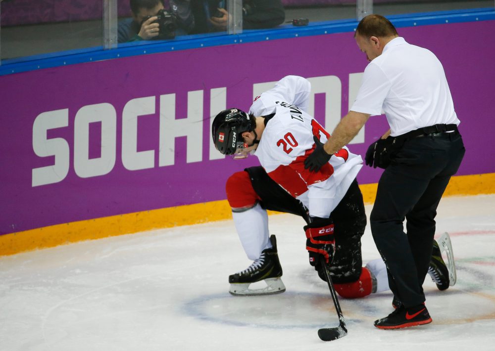 FILE - Canada forward John Tavares is helped up off the ice by a trainer during the second period of a men's quarterfinal ice hockey game against Latvia at the 2014 Winter Olympics, Wednesday, Feb. 19, 2014, in Sochi, Russia. (AP Photo/Mark Humphrey, File)