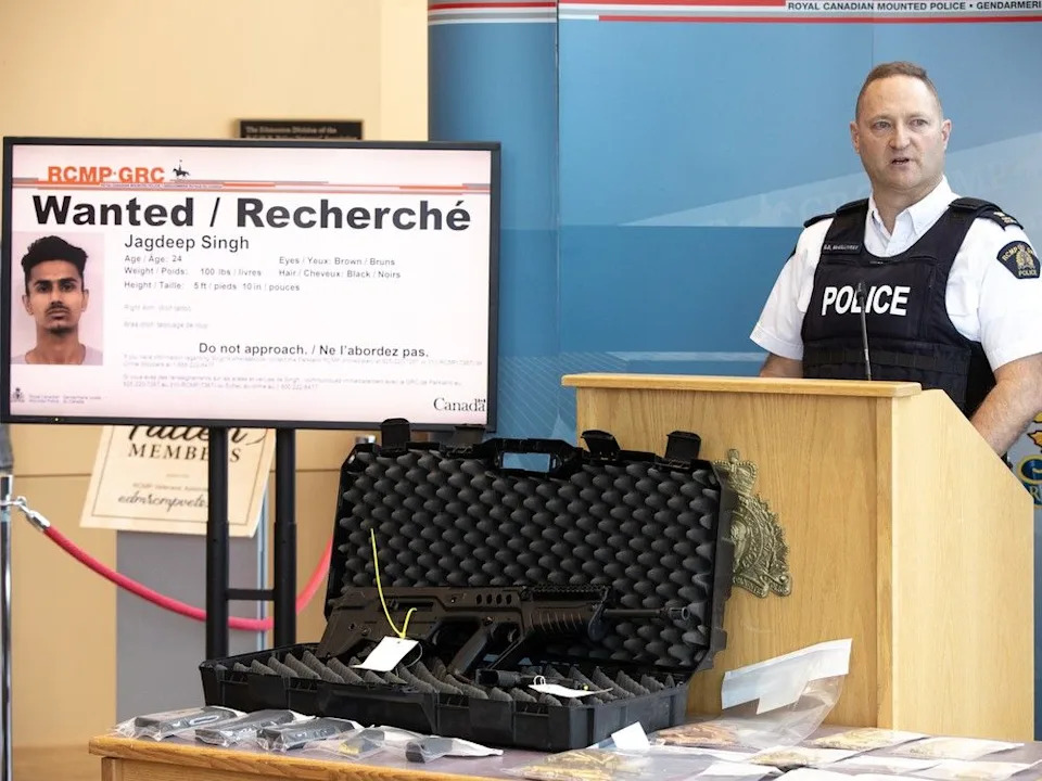 A semi-automatic rifle and a mugshot are displayed Friday by RCMP Inspector Kevin McGillivray in Edmonton as Parkland County RCMP announced a search for suspect Jagdeep Singh, who is also wanted in B.C.