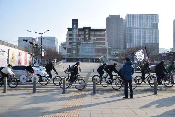 Cyclists ride past Sewoon Arcade during a Critical Mass ride in Seoul, Jan. 17. To the left is the fence surrounding the controversial Sewoon District 4 development zone. Courtesy of Bereket Alemayehu