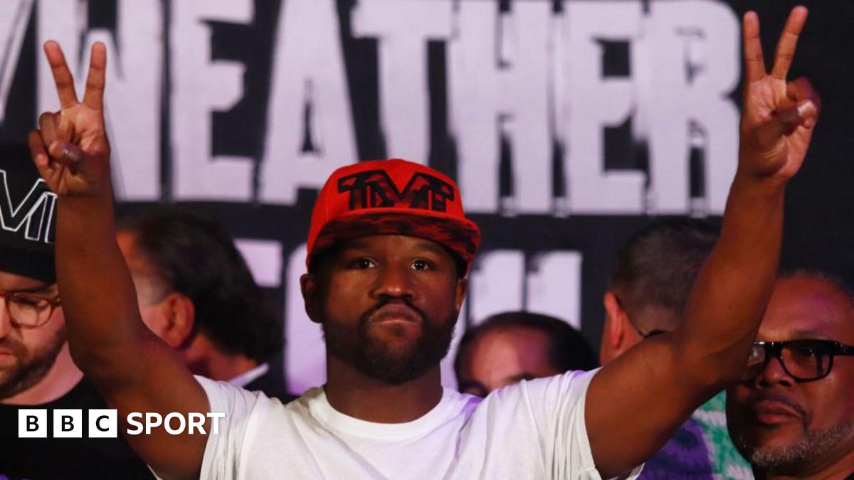 Floyd Mayweather raises his hands in the air during a  weigh-in