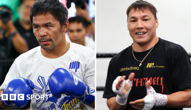 Manny Pacquiao on the left is wearing a white T-shirt and holding up his hands in blue boxing gloves. Ruslan Provodnikov is wearing a black T-shirt and clapping his hands
