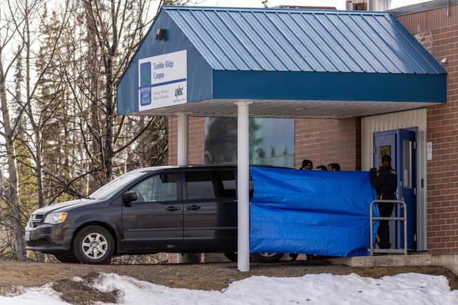 Police officers and investigators work outside the middle school and high school building where a mass shooting took place in the small town of Tumbler Ridge, British Columbia, on February 11, 2026.