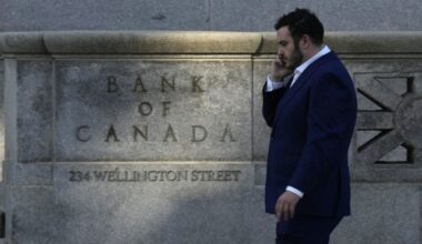 A man speaks on the phone as he walks past the Bank of Canada in Ottawa on Wednesday, Sept. 17, 2025. THE CANADIAN PRESS/Adrian Wyld