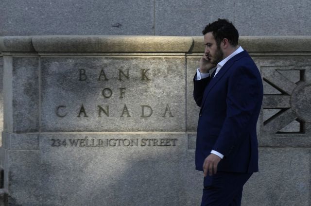 A man speaks on the phone as he walks past the Bank of Canada in Ottawa on Wednesday, Sept. 17, 2025. THE CANADIAN PRESS/Adrian Wyld