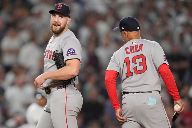 Boston Red Sox pitcher Garrett Crochet comments to manager Alex Cora (13) as he walks off the field during the eighth inning of Game 1 of an American League wild-card baseball playoff series against the New York Yankees, Tuesday, Sept. 30, 2025, in New York. (AP Photo/Frank Franklin II)