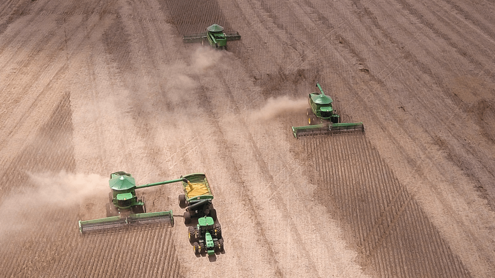 Four tactors plow dry, brown fields.