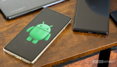 Android robot on smartphone next to other devices and accessories (4)