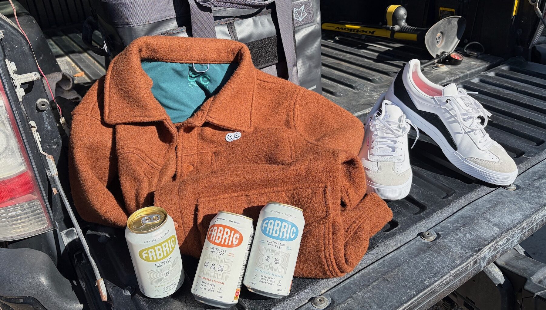 Curious Creatures Jacket, Five Ten Shoes, and Fabric hop waters on a truck tailgate