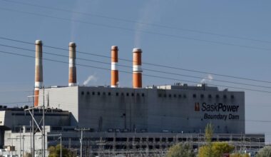 Transmission power lines behind a large coal-powered dam.