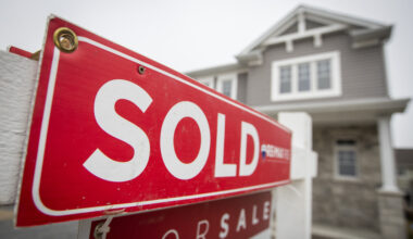 A real estate for sale sign in front of a house in Kingston, Ontario, illustrating real estate market activities.
