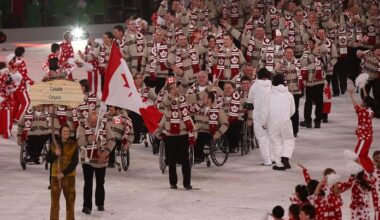 A group of Para athletes waving Canadian flags take part in the Parade of Nations